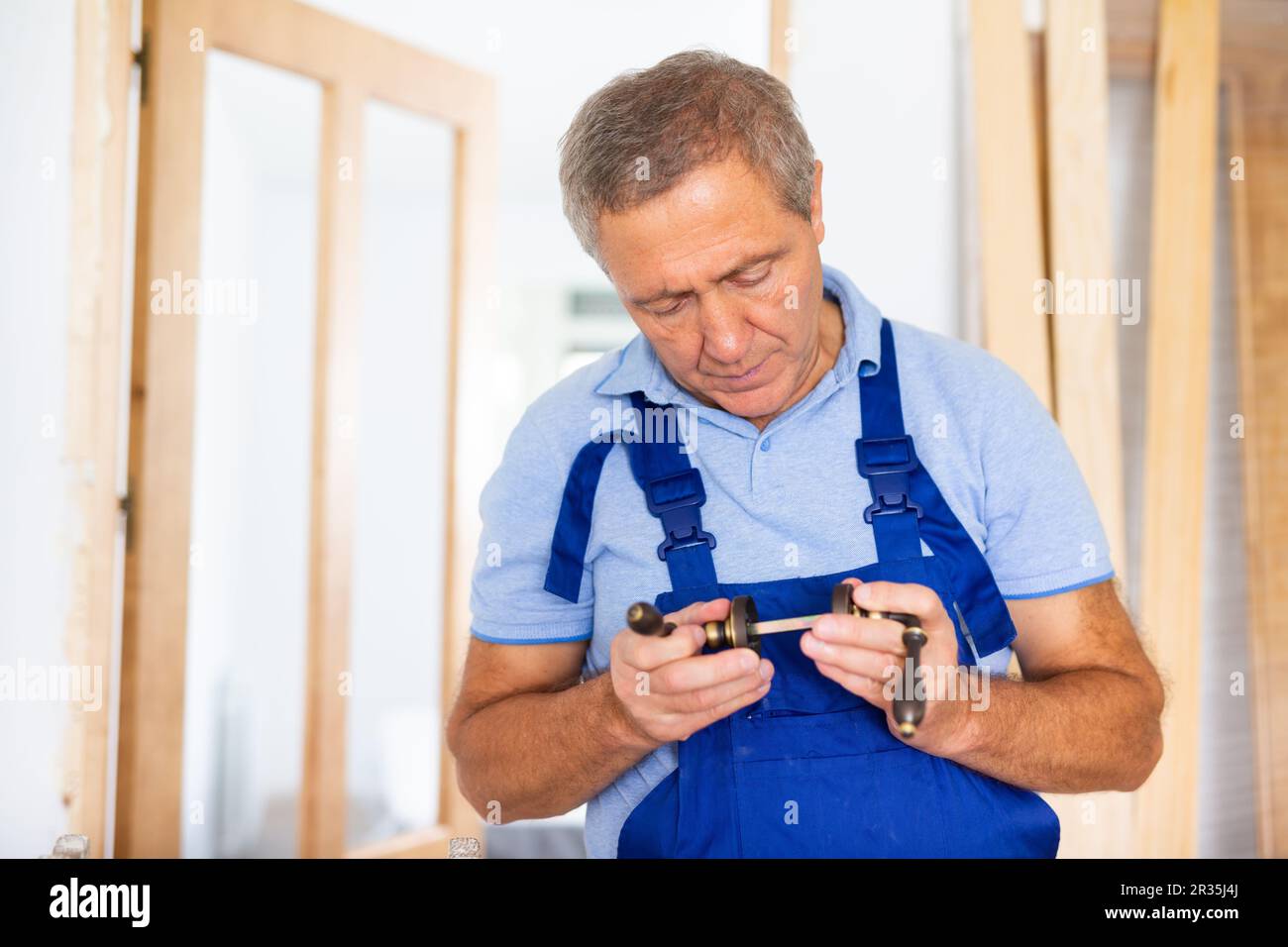 Professional door installer checks operation of bronze door handles