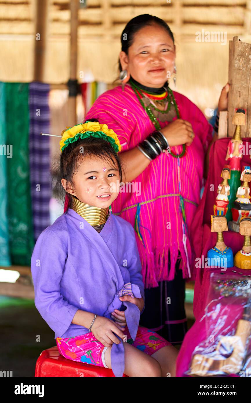 woman from the longnecked tribe, known for the metal rings worn around their necks, holding her