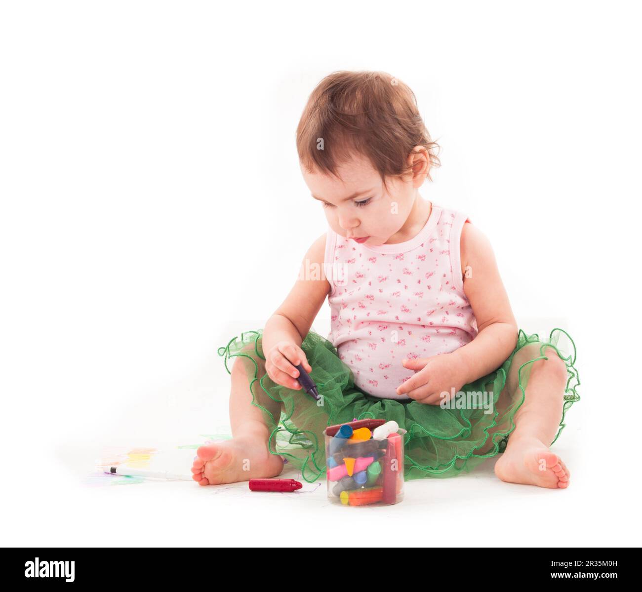 Toddler girl draws with wax crayons on the paper Stock Photo - Alamy