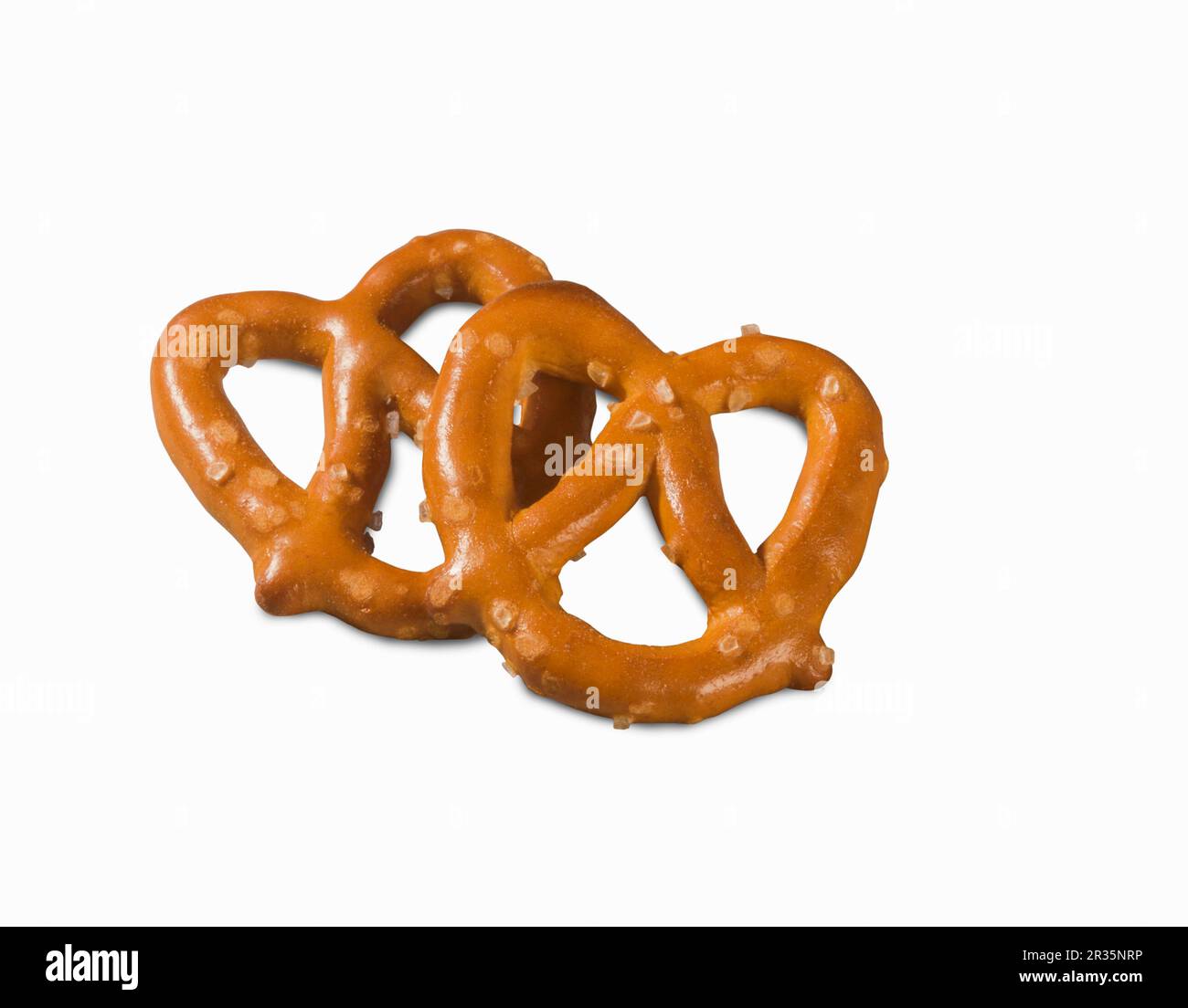 Two mini salted pretzels on a white surface (close-up) Stock Photo