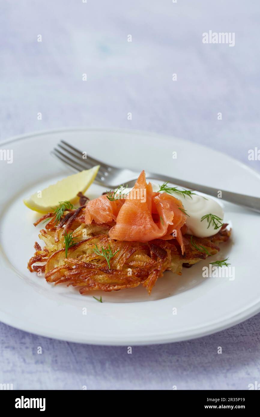 A potato fritter with salmon, crème fraîche and dill Stock Photo