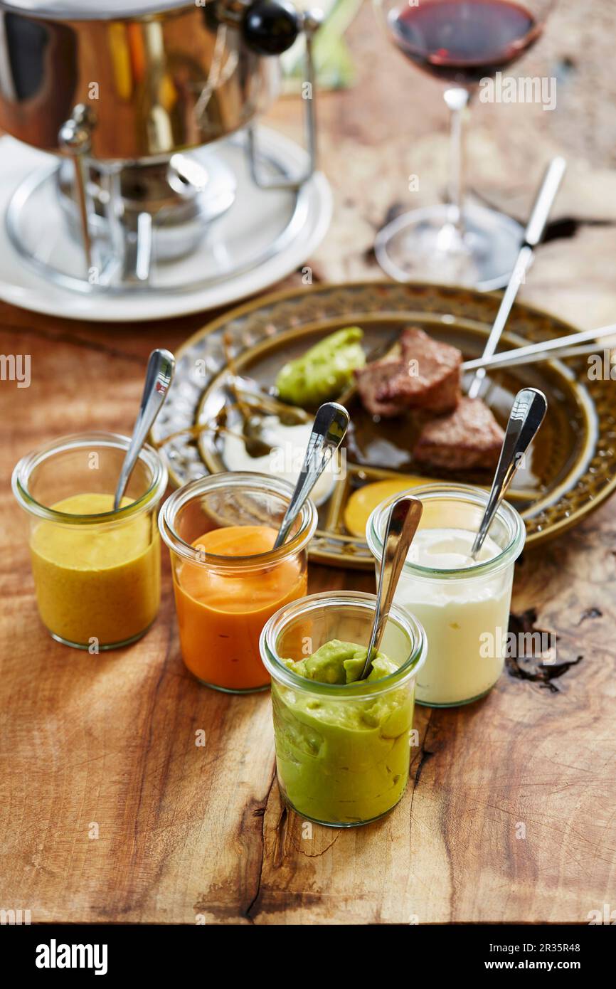 Meat fondue and various sauces Stock Photo Alamy