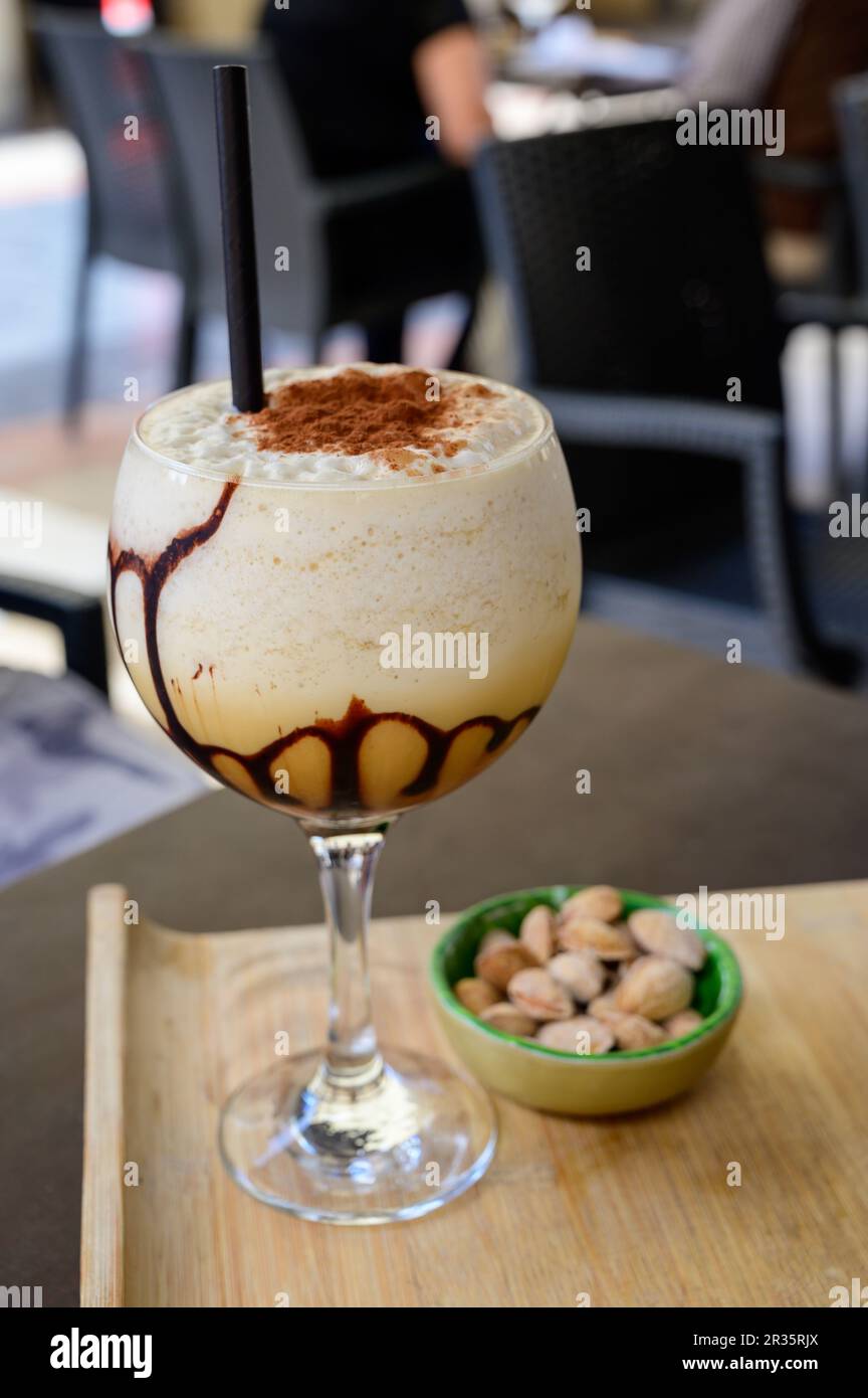 Glaass of iced frappuccino coffee with whipped cream, chocolate and ice