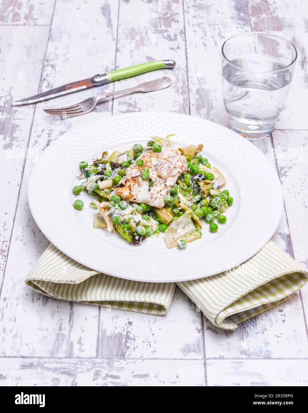 Braised cod on a bed of peas and steamed lettuce Stock Photo