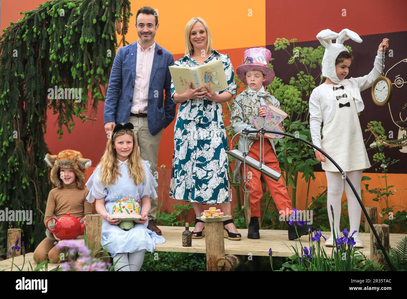 London, UK. 22nd May, 2023. In the Teapot Trust Elsewhere Garden, Former CBBC smART presenter, Kirsten O'Brien, joins the Mad Hatter's 'Teapot Trust' Tea Party as it takes over the garden whilst children take on the roles of Alice, Mad Hatter, Dormouse and White Rabbit. Press day at the annual RHS Chelsea Flower Show, showcasing garden designs, products, floral displays and all things horticultural from May 23-27. Credit: Imageplotter/Alamy Live News Stock Photo