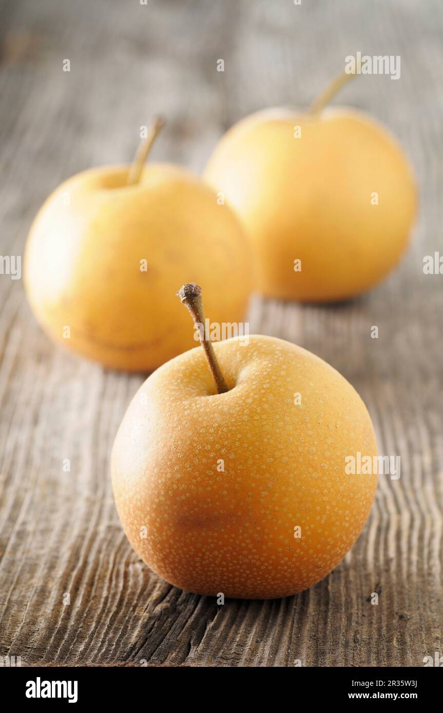 Three Nashi pears on a wooden surface Stock Photo