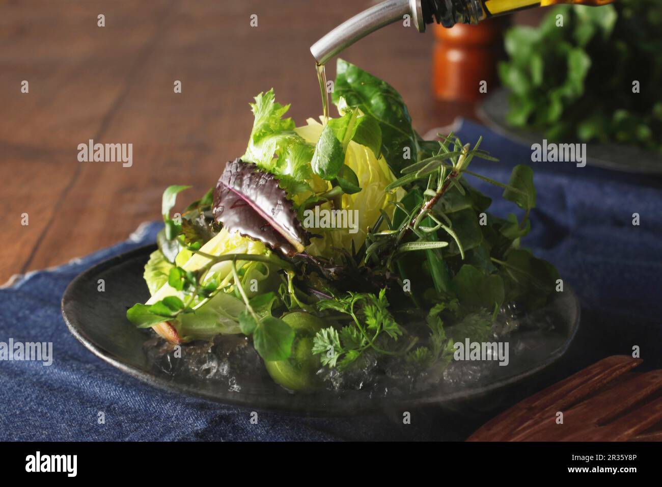 Olive oil being poured over iceberg lettuce Stock Photo Alamy