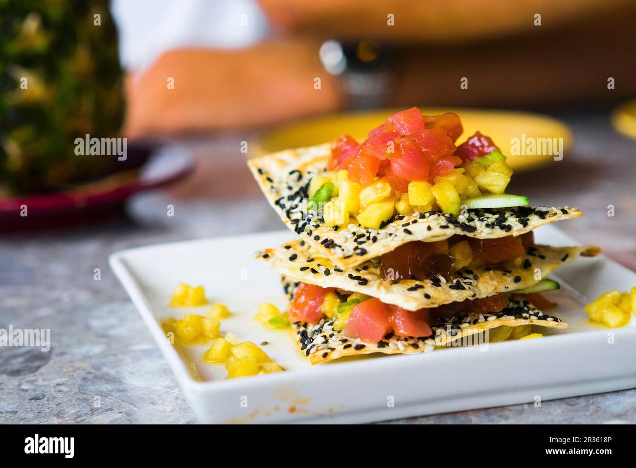 A millefeuille with sesame seed crisps, tuna fish and fruit Stock Photo
