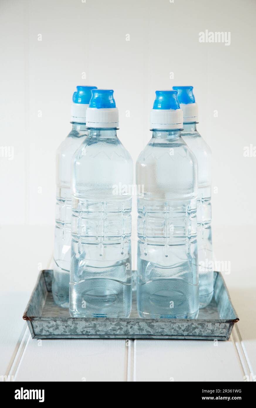 Four bottles of water on a metal tray Stock Photo Alamy