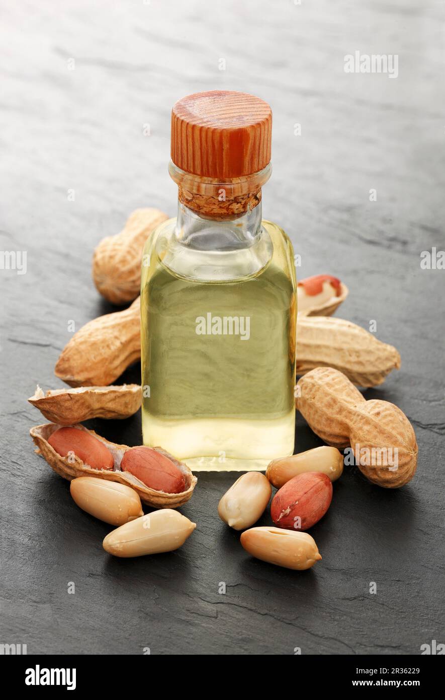 A bottle of peanut oil surrounded by peanuts Stock Photo Alamy
