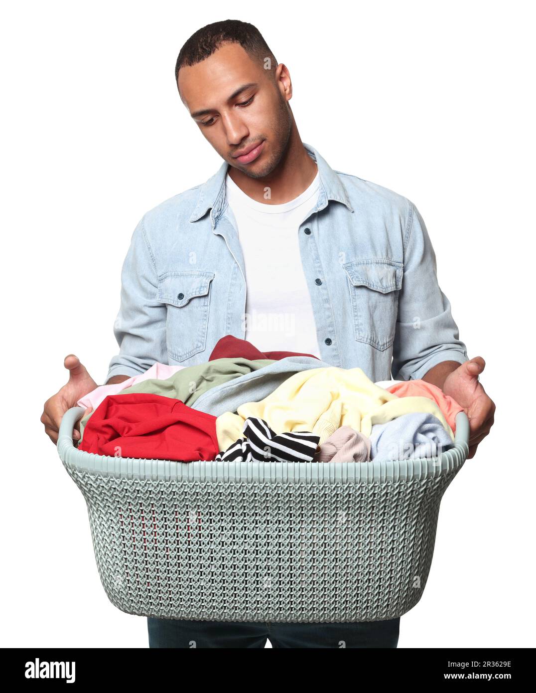 Young man with basket full of laundry on white background Stock Photo