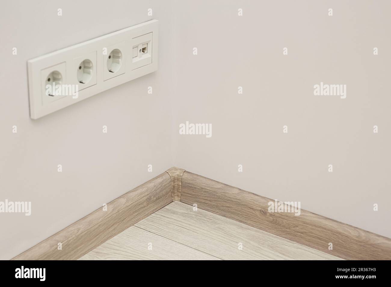 White wall with sockets and baseboard indoors, space for text Stock ...