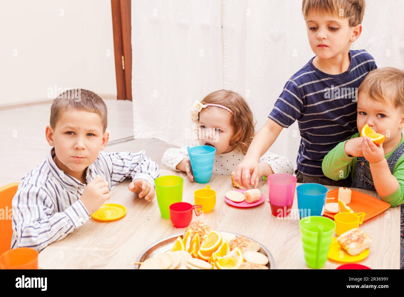 Group of happy children enjoying party on birthday in kindergarten