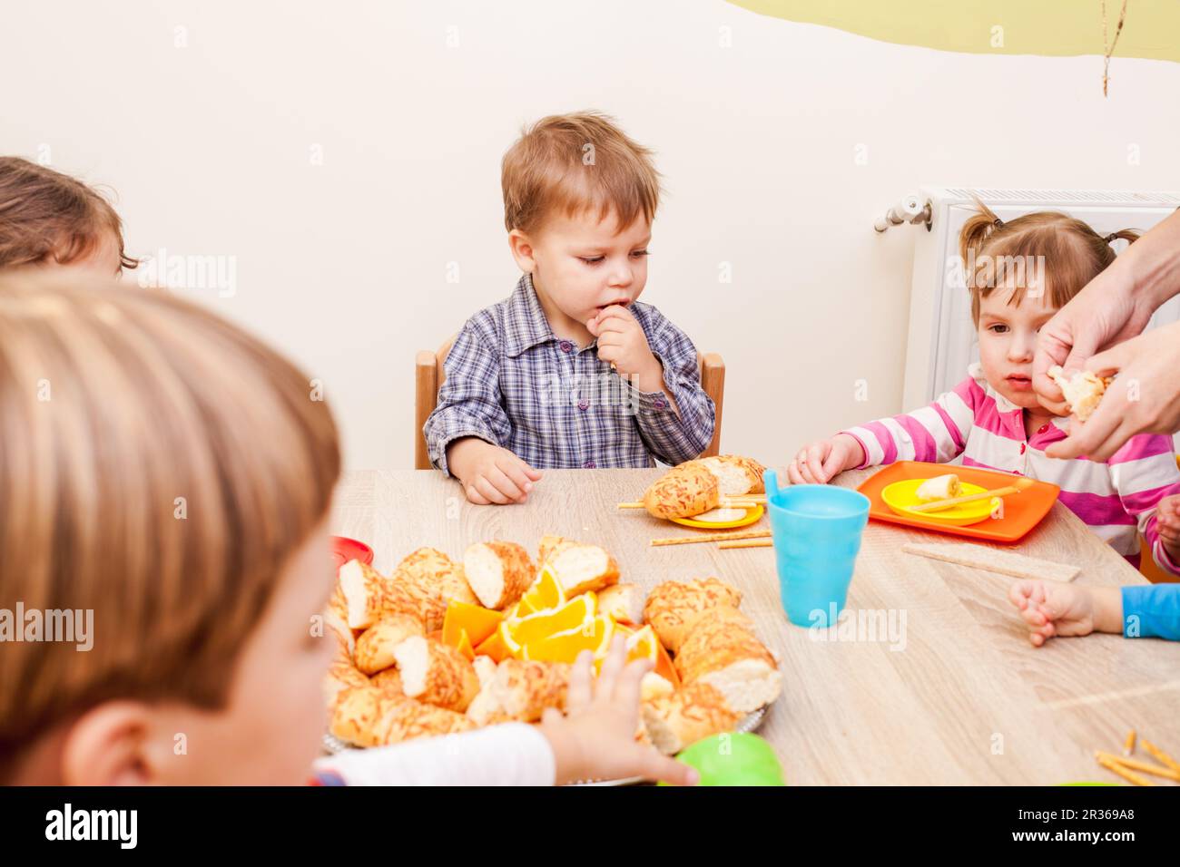 Group of happy children enjoying party on birthday in kindergarten