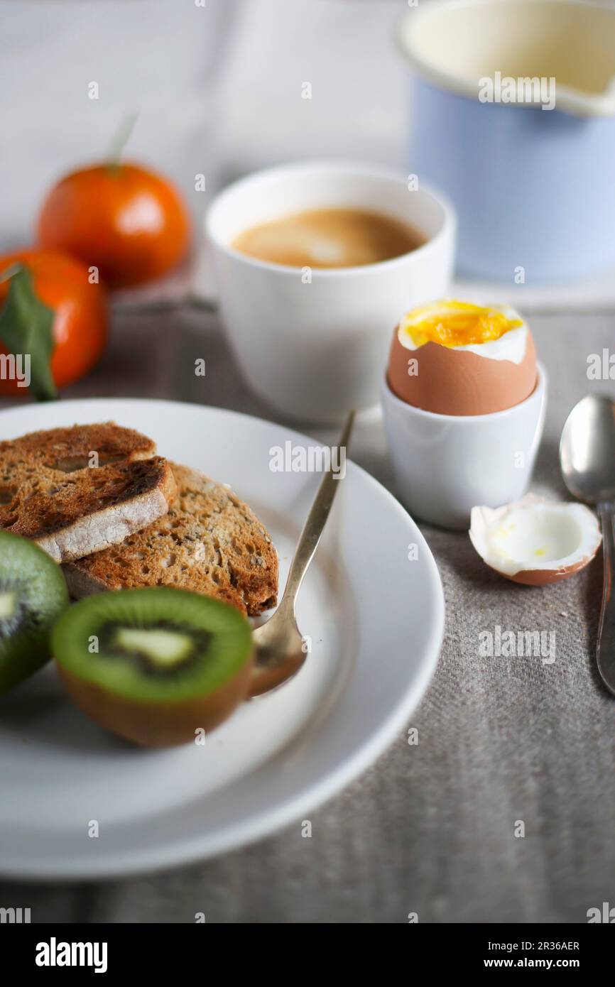 Breakfast with a soft boiled egg, fresh fruit, toast and coffee Stock Photo