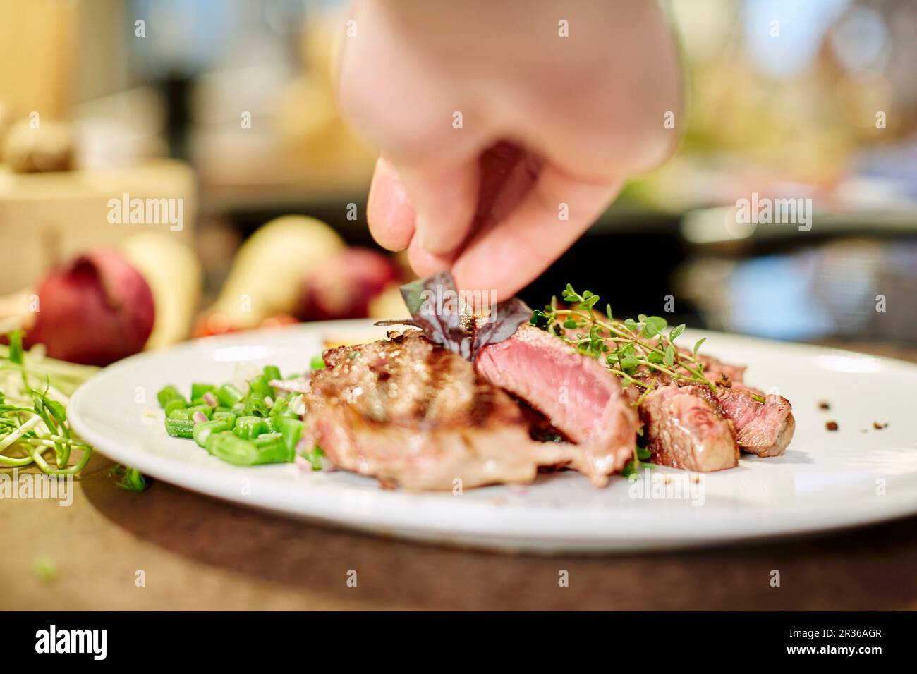 Grilled beef steak being garnished Stock Photo