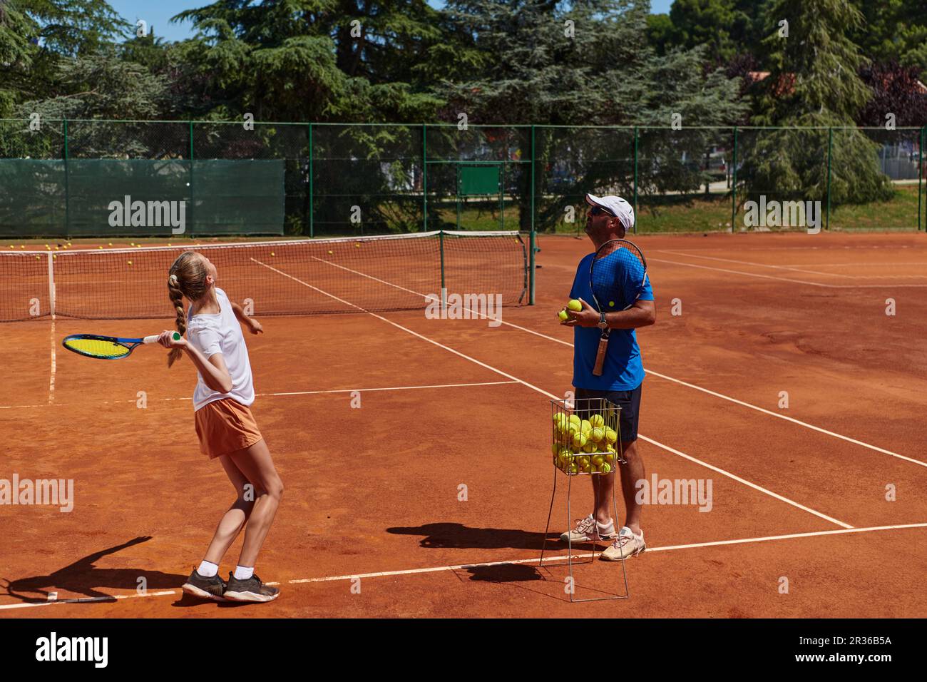 A professional tennis player and her coach training on a sunny day at