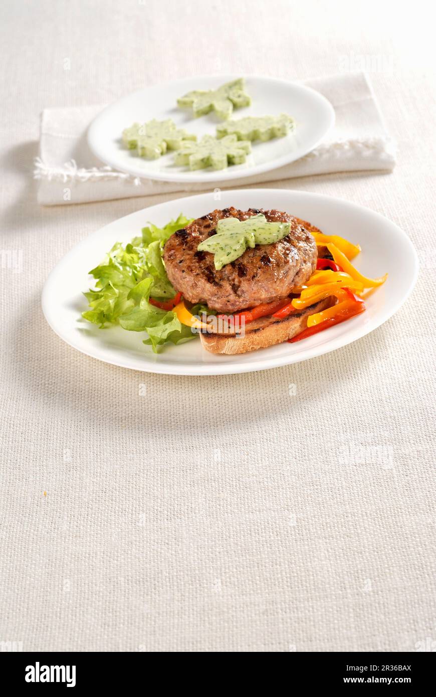 A veal burger on toast with herb butter Stock Photo
