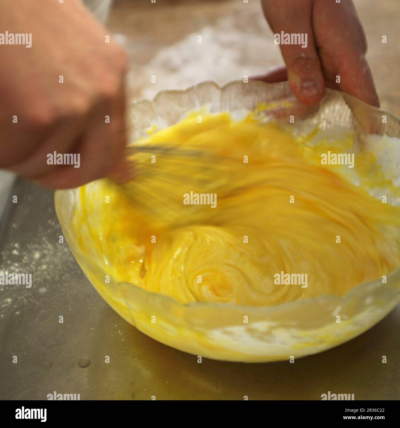 Egg yolk being beaten with a whisk Stock Photo