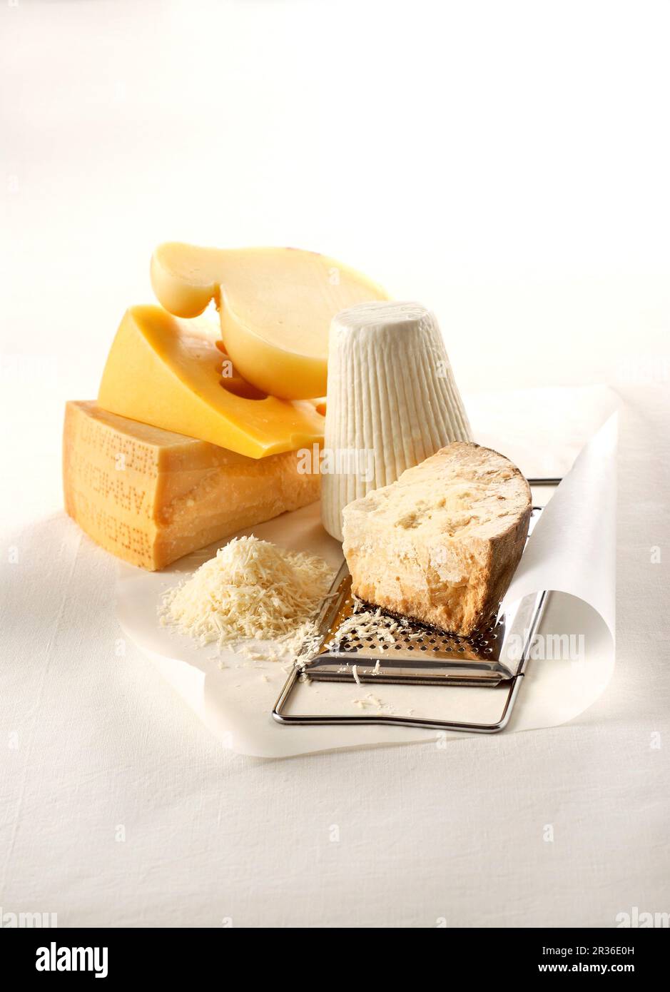 Five grateable hard cheeses, grated cheese and a cheese grater Stock Photo