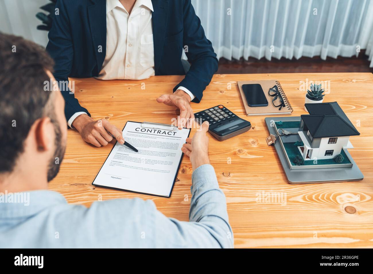 Client and real estate agent review loan contract, discussing term