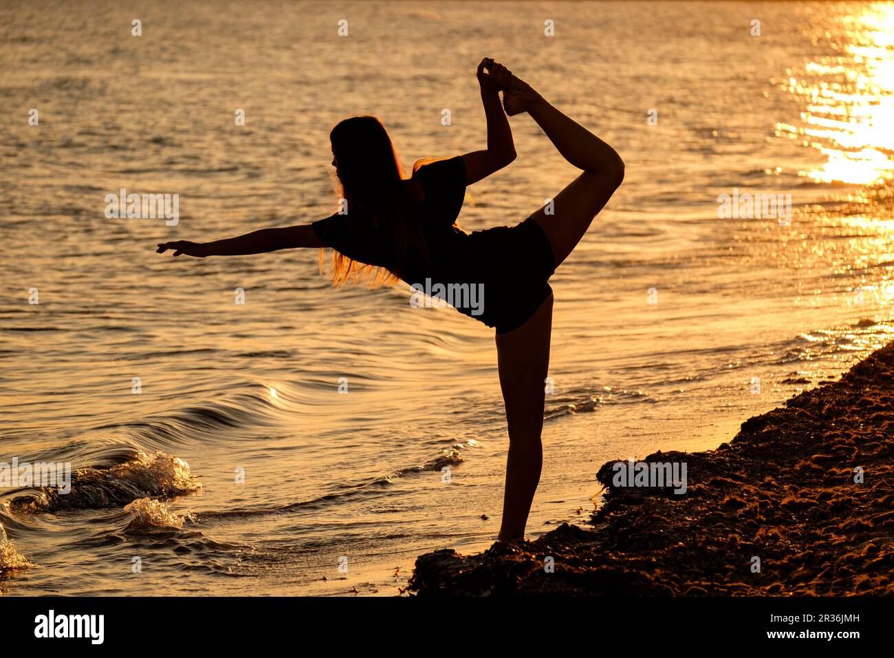 mujer joven practicando yoga, playa de Sa Rapita, Campos, Mallorca, balearic islands, Spain. Stock Photo