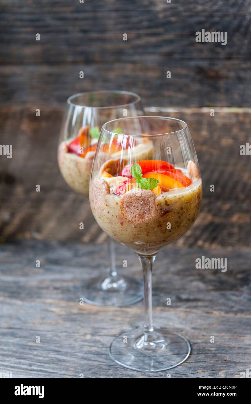 Chia pudding with bananas and nectarines in stemmed glasses Stock Photo
