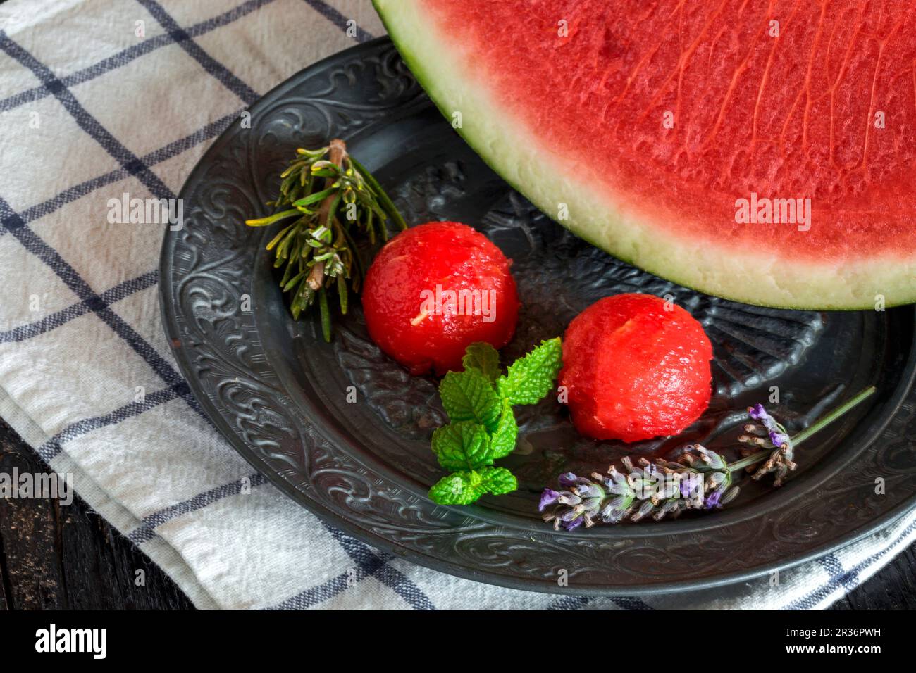 Watermelon and melon balls with rosemary and mint on a tin plate Stock Photo