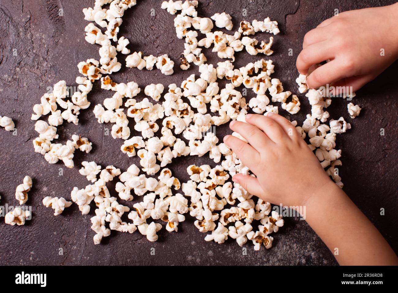 Children's hand holds popcorn Stock Photo