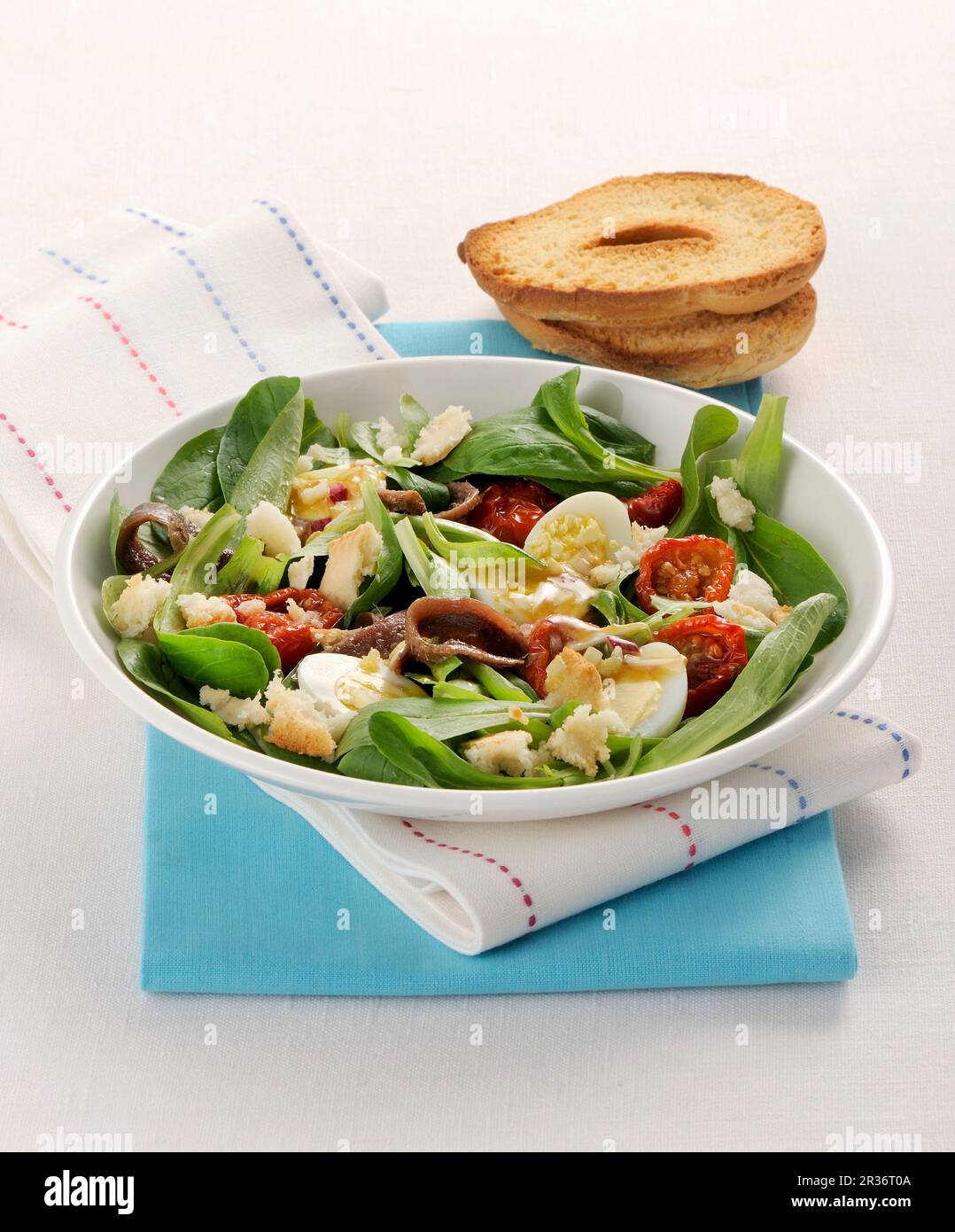 A green salad with quail eggs, anchovies and tomatoes Stock Photo