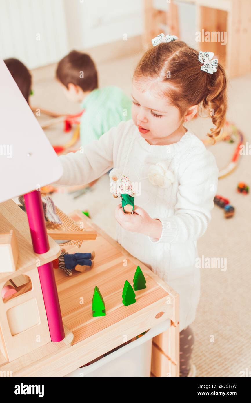 Girl playing with a dollhouse Stock Photo - Alamy