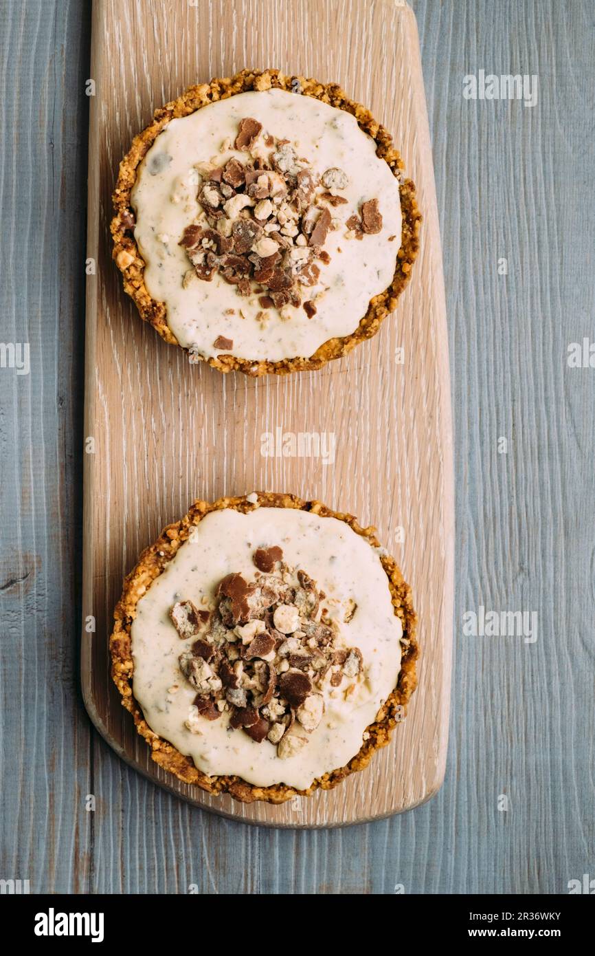 Biscuit tarts with malted milk, caramel, ice cream and Maltesers Stock