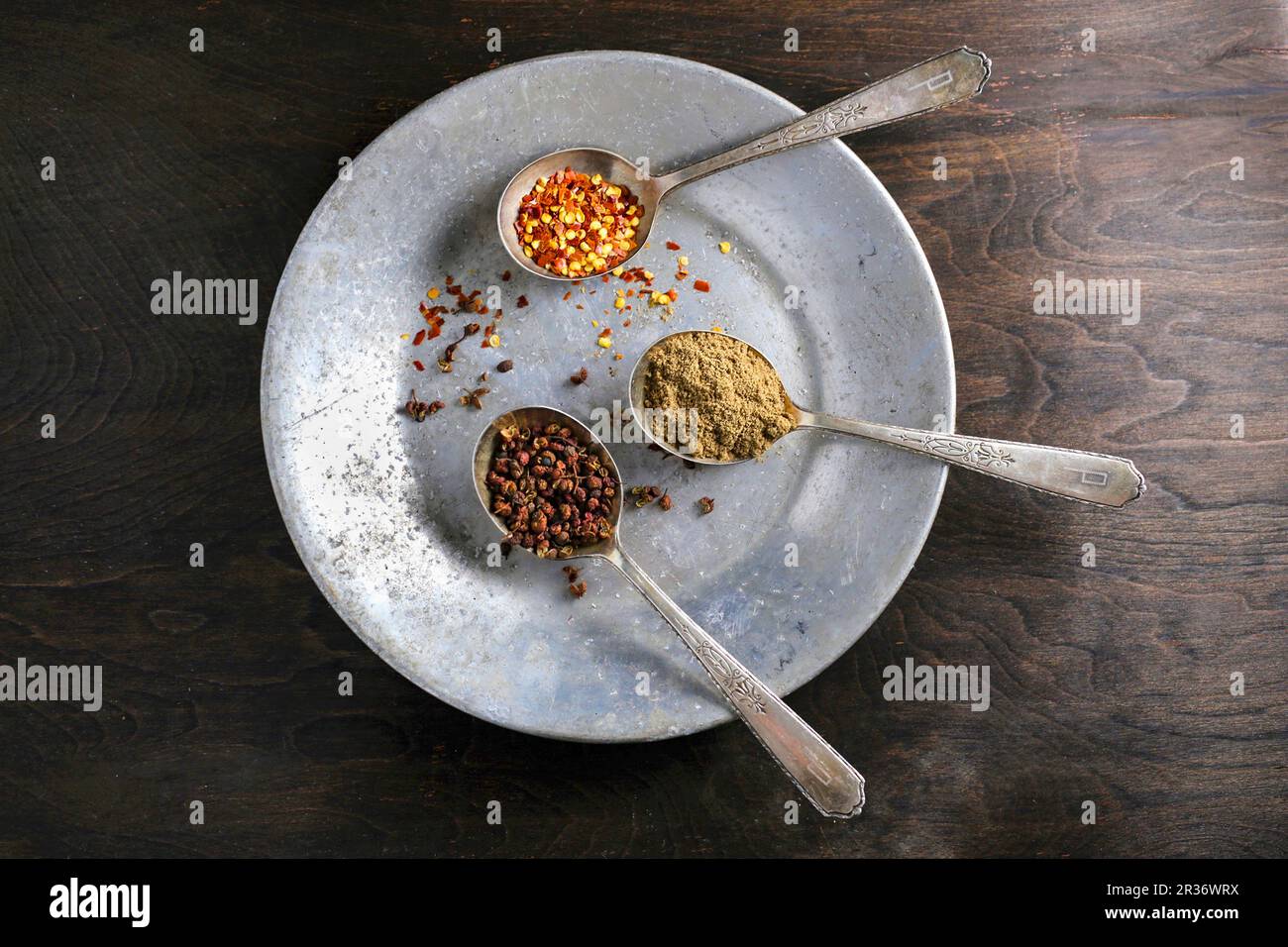 https://c8.alamy.com/comp/2R36WRX/three-spoons-containing-spices-on-a-metal-plate-2R36WRX.jpg