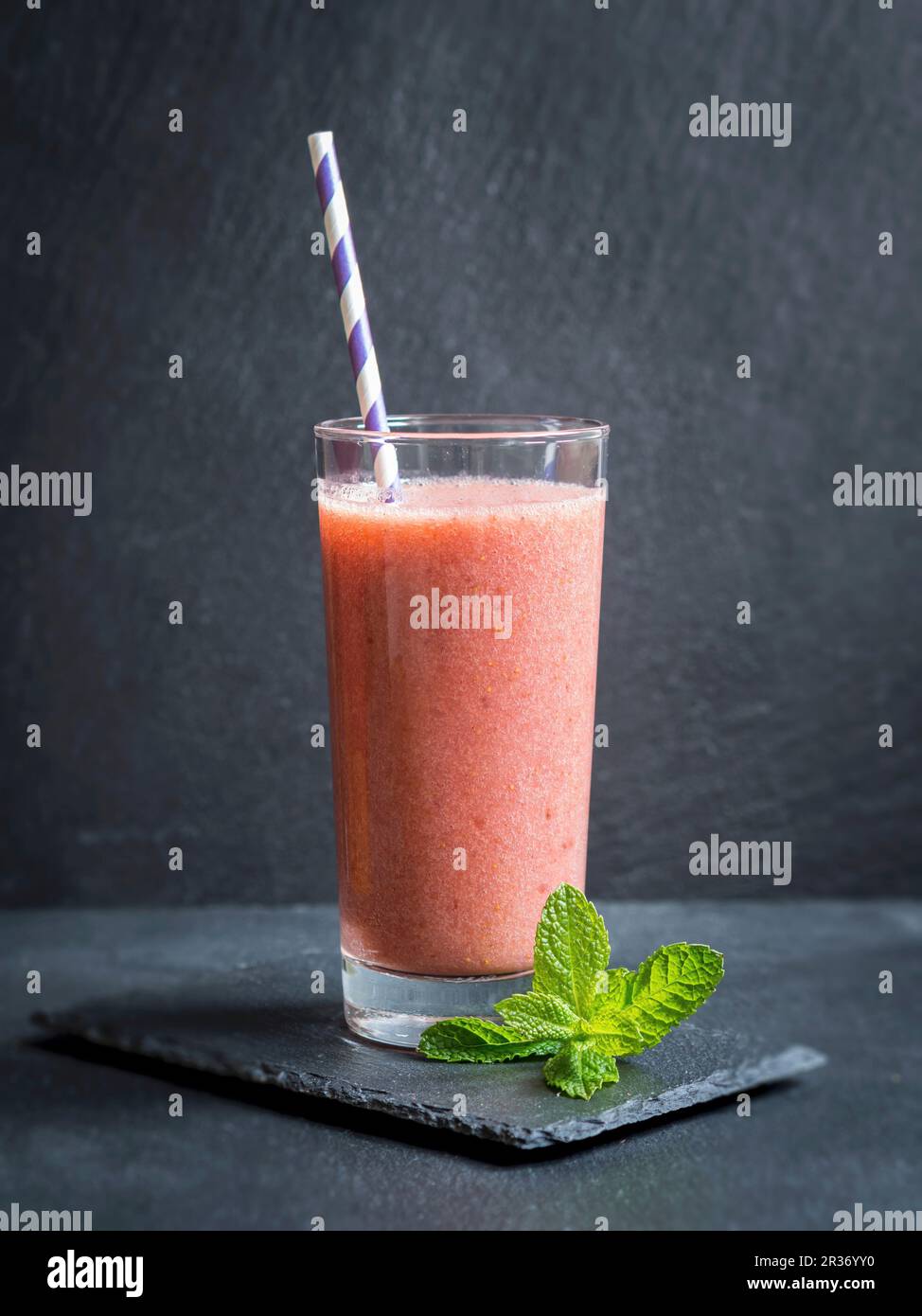 Dairy-free vegan red fruit smoothie in a glass with a straw Stock Photo