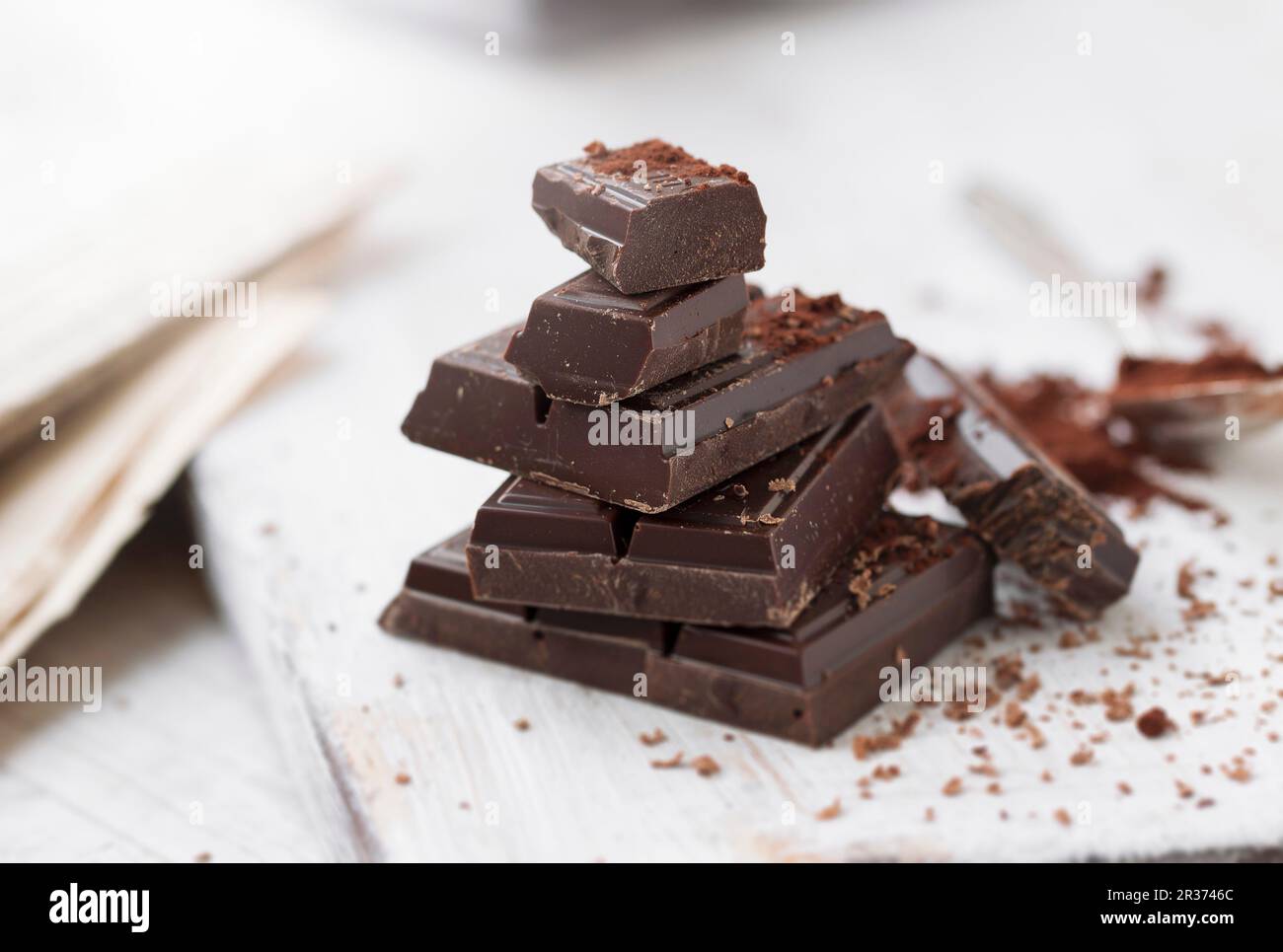 Stacked pieces of chocolate with cocoa powder on a chopping board Stock ...
