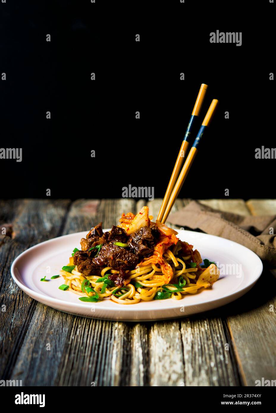 Panfried udon noodles with slow braised beef shank, kimchi and spring