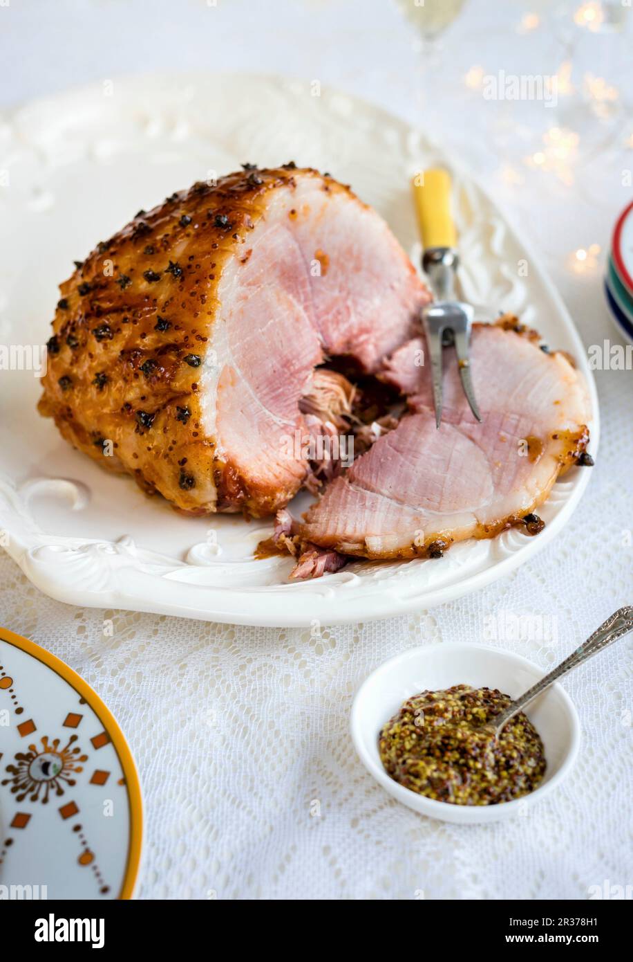 Glazed ham and coarse mustard garnished with carnations Stock Photo