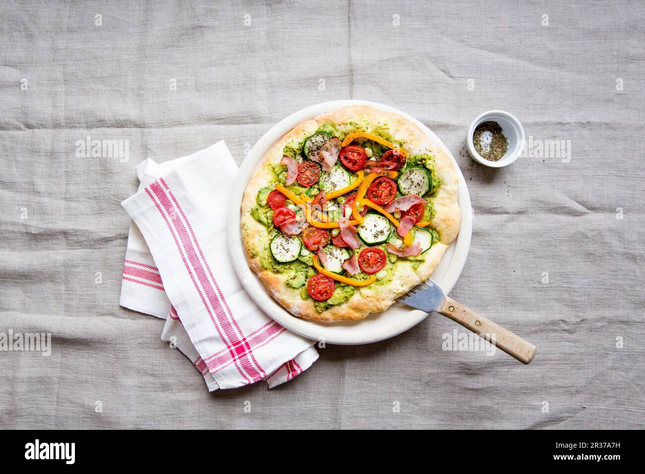 Pizza with avocado, zucchini, tomatoes, peppers and ham Stock Photo - Alamy
