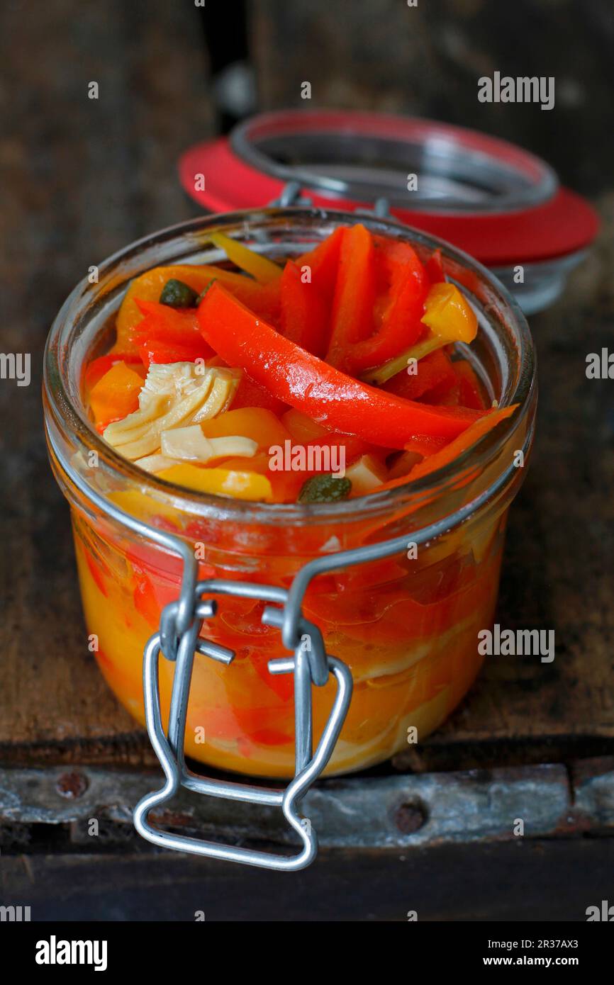 Italian Pickled Peppers in a Jar on a rustic wood background Stock
