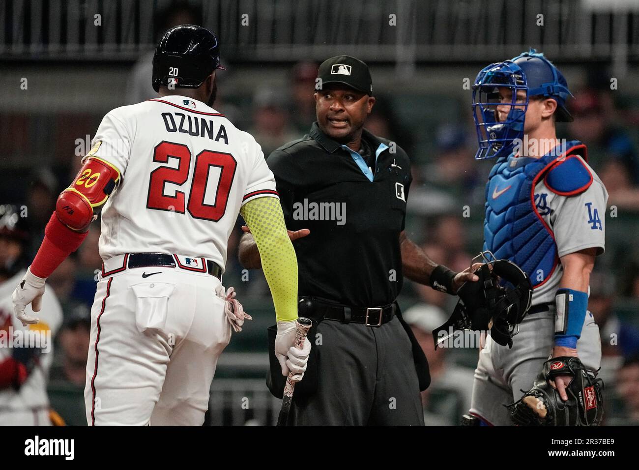 Home plate umpire Alan Porter, center, gets between Atlanta Braves