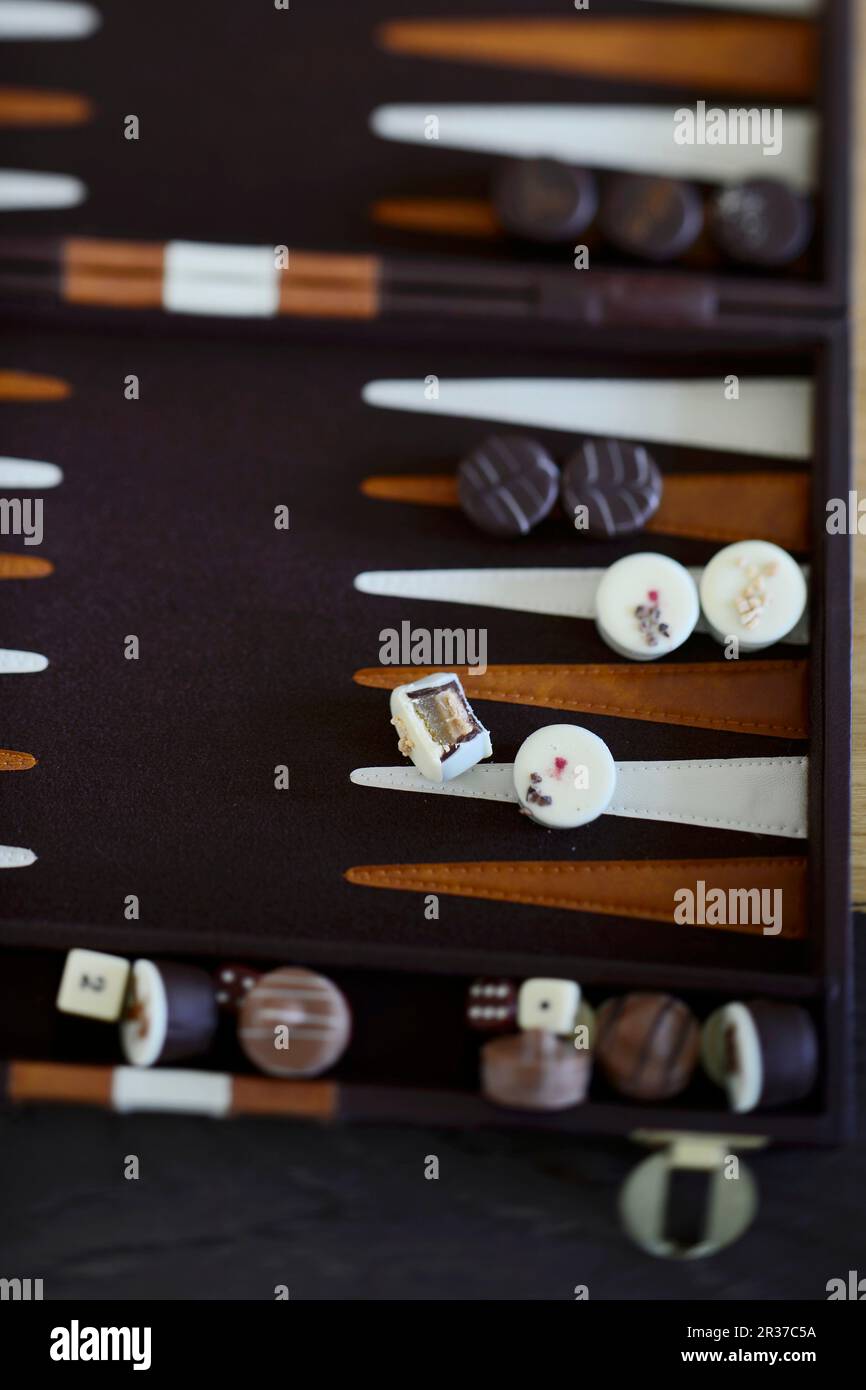 Various chocolates on a backgammon board Stock Photo