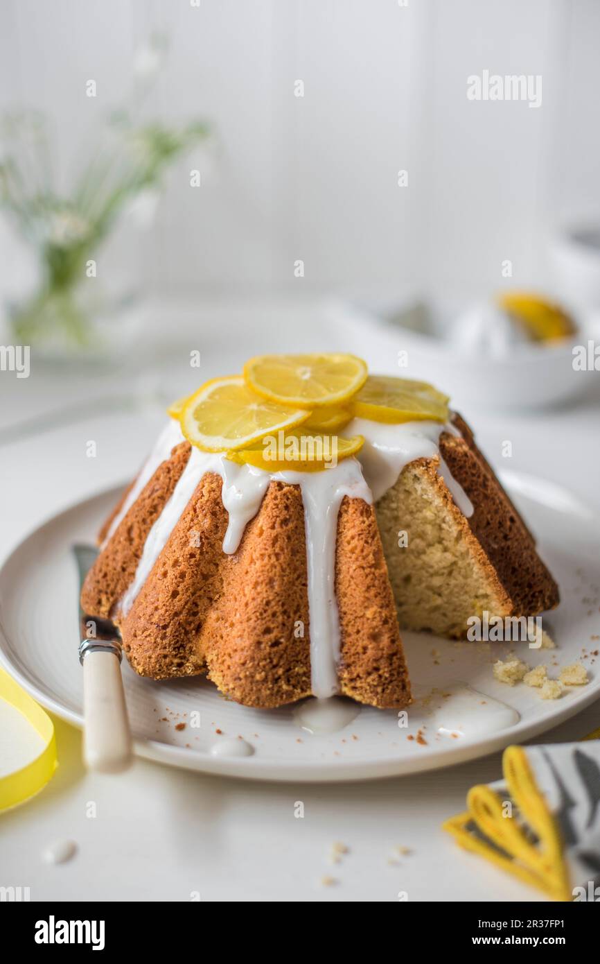 Lemon sponge cake with lemon icing and fresh lemon slices, slice