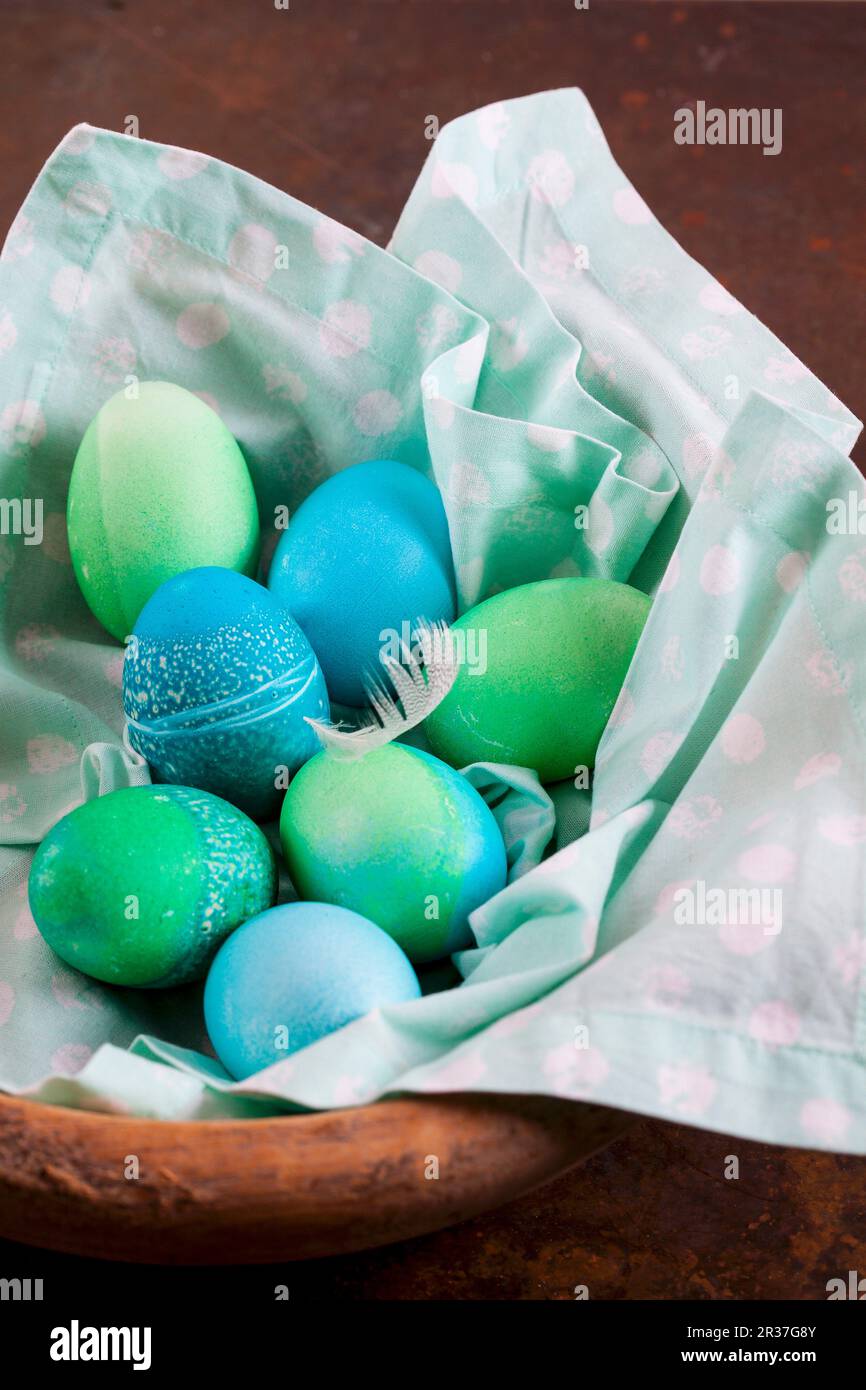 Dyed Easter eggs with batik patterns on a cloth in a basket Stock Photo
