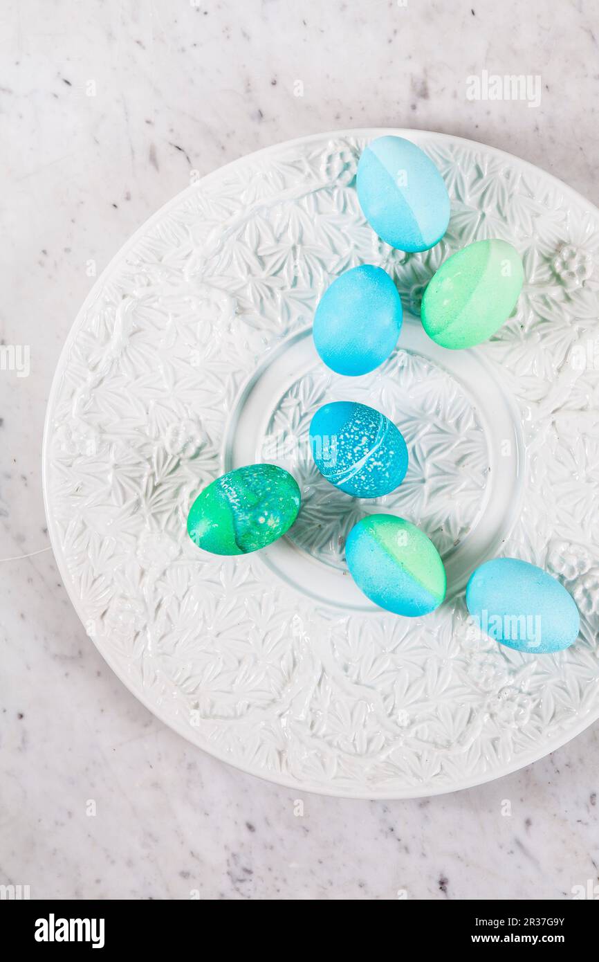 Dyed Easter eggs with batik patterns on a ceramic plate Stock Photo