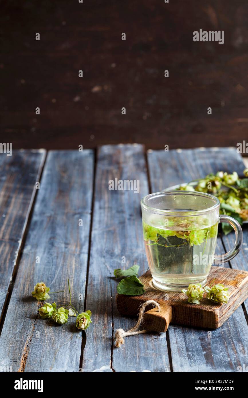 Hops tea in a glass cup on a chopping board Stock Photo