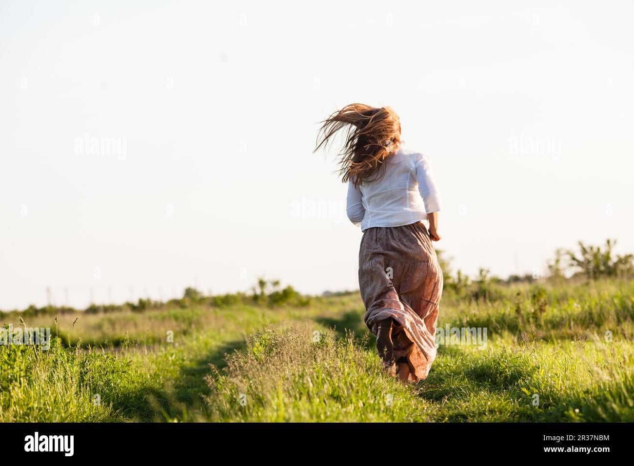 The girl ran across the field Stock Photo - Alamy
