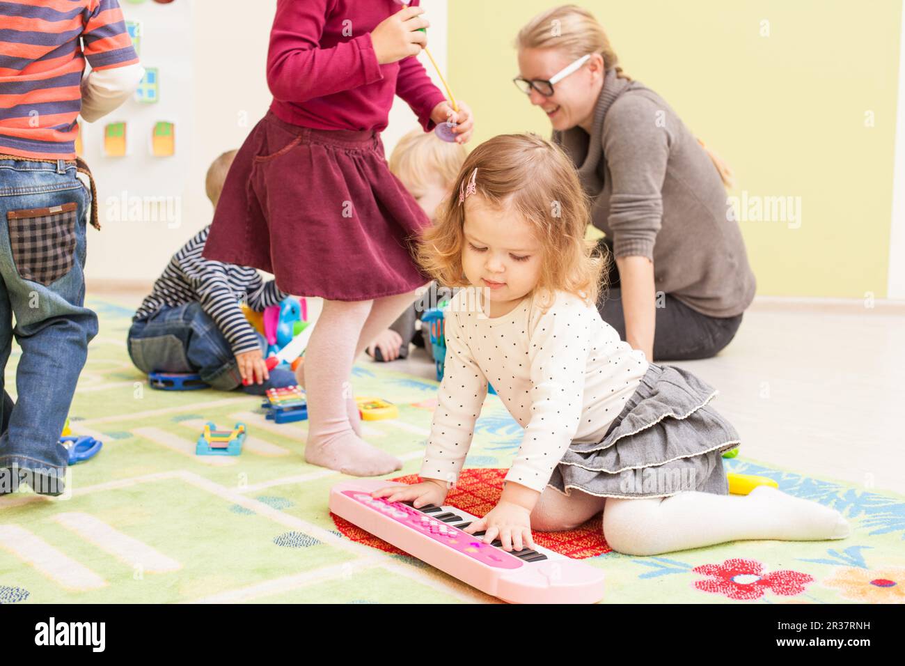 Nursery playground teacher children playing hi-res stock photography ...