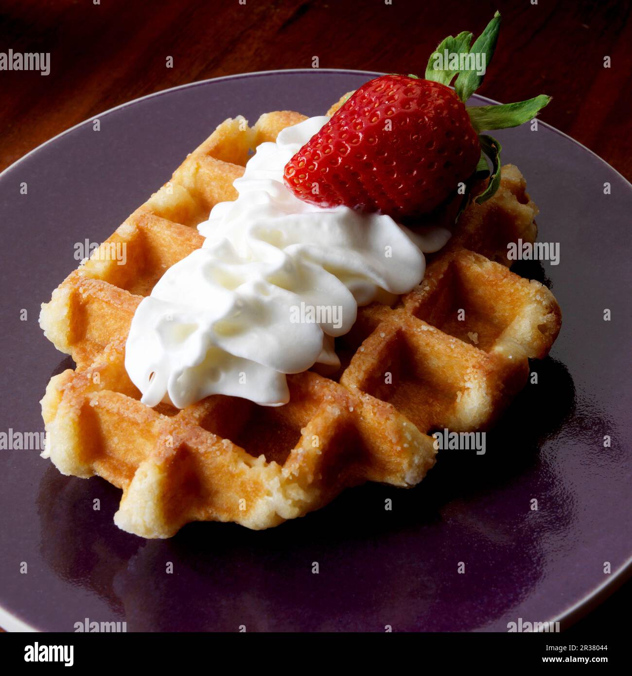 Belgian waffle with whipped cream and one strawberry Stock Photo - Alamy