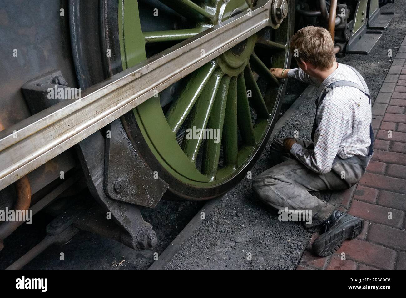 Young man cleaning a steam train wheel Stock Photo Alamy