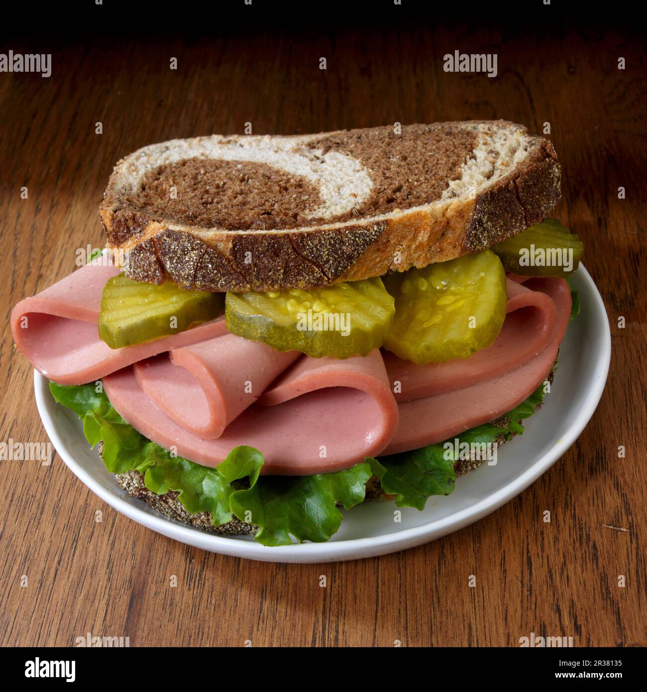 Bologna sandwich with lettuce and dill pickle on marble rye Stock Photo